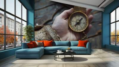 Hand Holding a Compass: A hand holding a brass compass, evoking a sense of adventure and direction.
 Wall mural