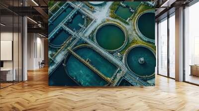 Aerial view of a modern wastewater treatment facility showing multiple tanks and filtration systems in a green landscape. Wall mural