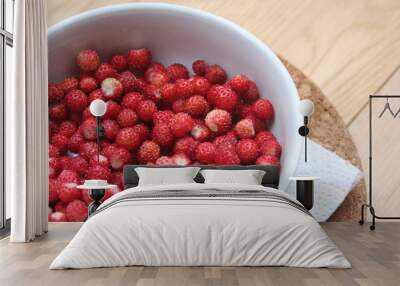 Fresh wild strawberries in a bowl on wooden table Wall mural