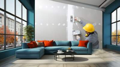 interior decoration construction furniture builtin.Plasterer in working uniform plastering the wall indoors. Wall mural