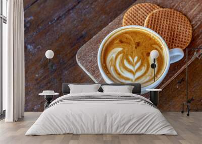 Selective focus a cup of cappuccino, Latte art coffee in white cup on wooden board served with two pieces Dutch waffle (Stroopwafel) Free copy space for your text. Wall mural