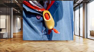 Selective focus of a men with blue polo wearing red scarf with wooden shoes woggle ring, Dutch man with traditional vintage costume in Edam, One of the famous cheese market, North Holland, Netherlands Wall mural