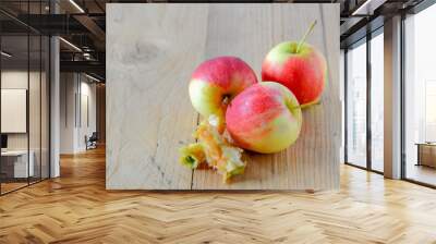 Three red apples,bite  on wooden floor. Wall mural