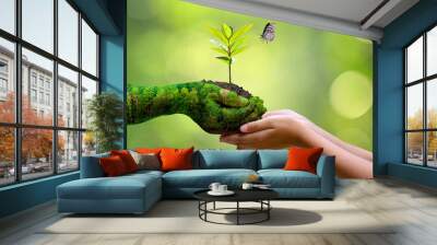 environment Earth Day In the hands of trees growing seedlings. Bokeh green Background Female hand holding tree on nature field grass Forest conservation concept Wall mural