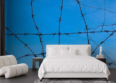 old barbed wire rusty tangle with blue sky and cloud Wall mural