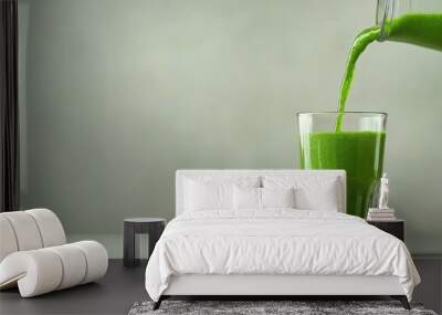 Fresh green smoothie being poured into a glass, showcasing vibrant color and healthy ingredients, ideal for wellness themes. Wall mural