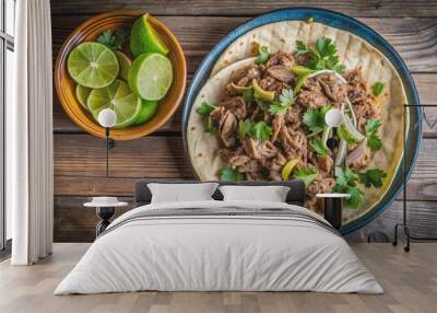 Platter of juicy carnitas served with fresh lime wedges and warm tortillas on a rustic wooden table, carnitas Wall mural