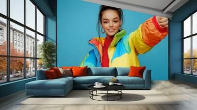 Young Woman in Colorful Puffer Jacket Giving Peace Sign Wall mural