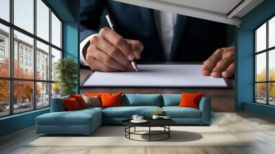 Businessman signing a document on a wooden desk. Professional contract or agreement in a formal setting with a focus on the hand and pen. Wall mural