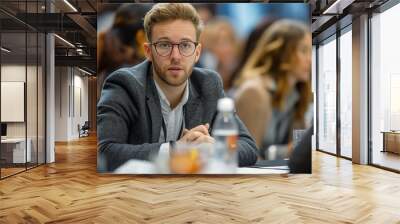 Focused young businessman in conference meeting, symbolizing strategic thinking and professional engagement concept Wall mural