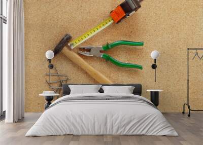 Hammer, pliers, tape measure and nails on cork. Wall mural