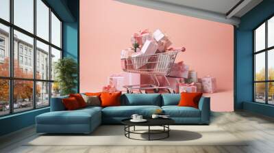 Shopping cart overflowing with wrapped gift boxes with pastel pink background. Wall mural