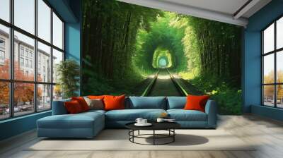 A train track running through a natural tunnel of thick, green trees, creating an enchanting and serene atmosphere in the Tunnel of Love, Ukraine. Wall mural