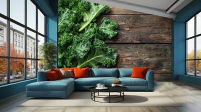 Freshly washed kale leaves spread out on a rustic wooden table with droplets of water shining in the light. Wall mural