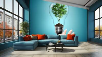 bulb light with tree inside on woman hand Wall mural