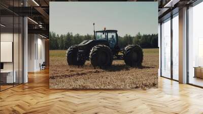 A tractor works the fields, preparing the ground for the next planting season in bright sunshine Wall mural