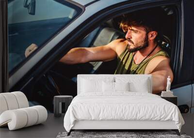 Hipster man driving a car on a sunny day Wall mural