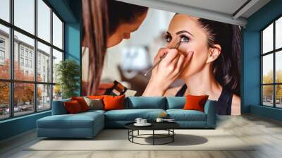 makeup artist applying eyeshadow on a girl Wall mural