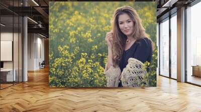 Beautiful woman in rapeseed field Wall mural