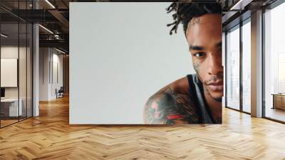 Man with tattoos on his arm and a shaved head Wall mural