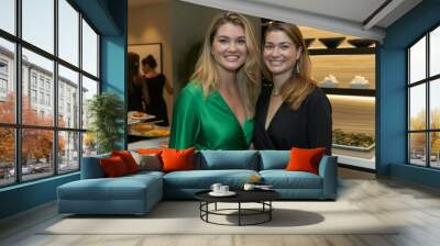 Two women are smiling and posing for a photo in front of a buffet table Wall mural