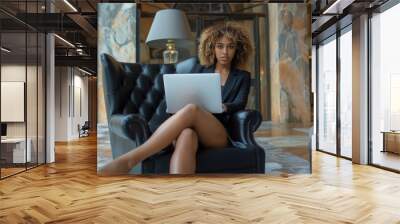 Woman, sexy black curly hair professional attire sitting working laptop Wall mural