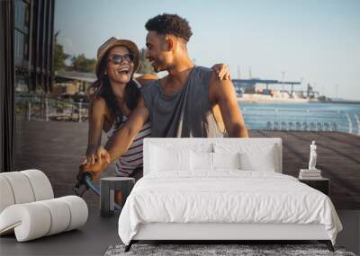 Portrait of a mixed race couple on tandem bicycle outdoors near the sea Wall mural