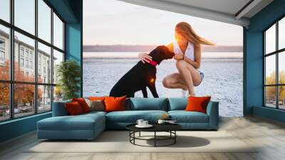 Young female training labrador retriever dog on the beach at sunset Wall mural