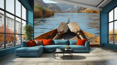 A wooden boat with oars on a calm river through a canyon. Wall mural