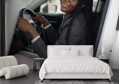 Black woman wearing smart casual sitting in the car Wall mural