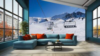 People riding ski lift in ski resort Wall mural