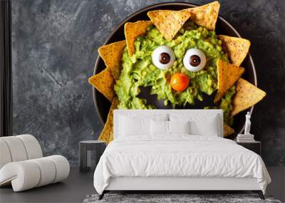 Guacamole served as monster with nachos. Halloween party dish. Wall mural