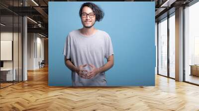 Young bearded man confident portrait in blue background. Wall mural