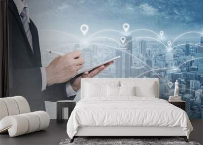 Double exposure businessman using digital tablet, and cityscape. Business network, blockchain technology and internet connection Wall mural