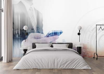 Double exposure businessman using smartphone and city in sunrise, with white copy space Wall mural