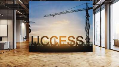 Success concept, Silhouette cranes and under construction building with SUCCESS  over sunset sky Wall mural