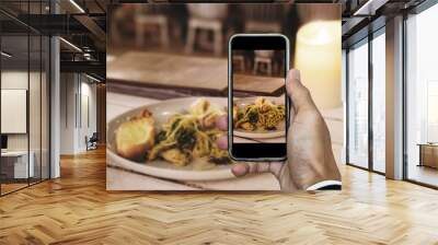 Taking food photo, dinner food photography by smart phone, seafood spaghetti under candle lights Wall mural