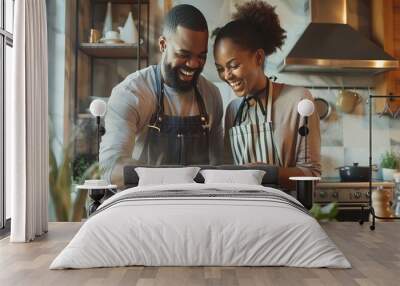 A couple laughing while cooking a meal together at home Wall mural