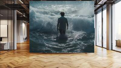 A man walking through the water with the waves parted. Wall mural