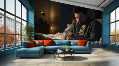 Depressed sleepy middle east young man. People using a smartphone on social media internet and sleeping on bed in bedroom at home. Lifestyle on late night in technology device concept. Wall mural