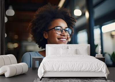 Happy cheerful African teen girl, smiling short-haired cute Black ethnic college student wearing eyeglasses looking away in modern university campus library. Wall mural