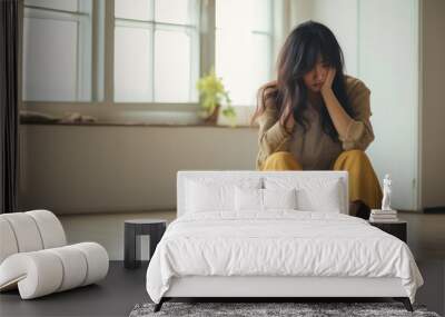 Sad and depressed young woman sitting on the floor in the living room looking outside the doors,sad mood,feel tired, lonely and unhappy concept. Wall mural