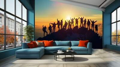 the silhouette of a large group against the setting sun on a mountaintop, their success pose reflect Wall mural