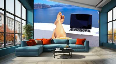 Digital nomad freelancer woman  lying and sunbathing as  remotely with bright scenic view of the Mediterranean Sea ,Oia -Santorini,Greece Wall mural