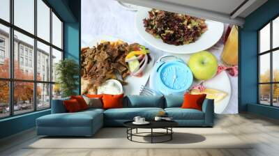 Selective of Alarm clock  and green apple on plate with intermittent fasting during breakfast with a healthy lifestyle of food concept for diet plan image Wall mural