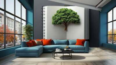 An open notebook features a lush, green tree growing from its pages, symbolizing knowledge, growth, and nature. Wall mural