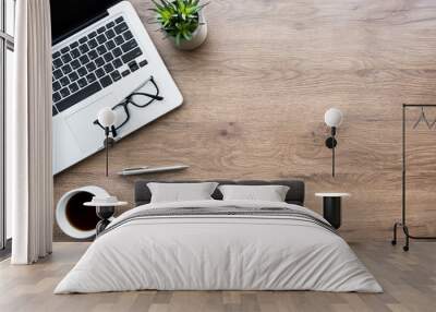 Wood office desk table with laptop computer, cup of coffee and supplies. Top view with copy space, flat lay. Wall mural