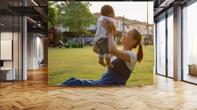 Portrait of happy loving mother and her baby outdoors Wall mural