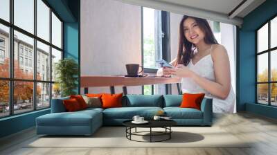 Young happy Asia woman using smartphone Wall mural