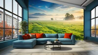 A misty morning scene with a vast expanse of green grass stretching towards a distant hill, outdoor scenery, green grass, hills, mist, landscape Wall mural